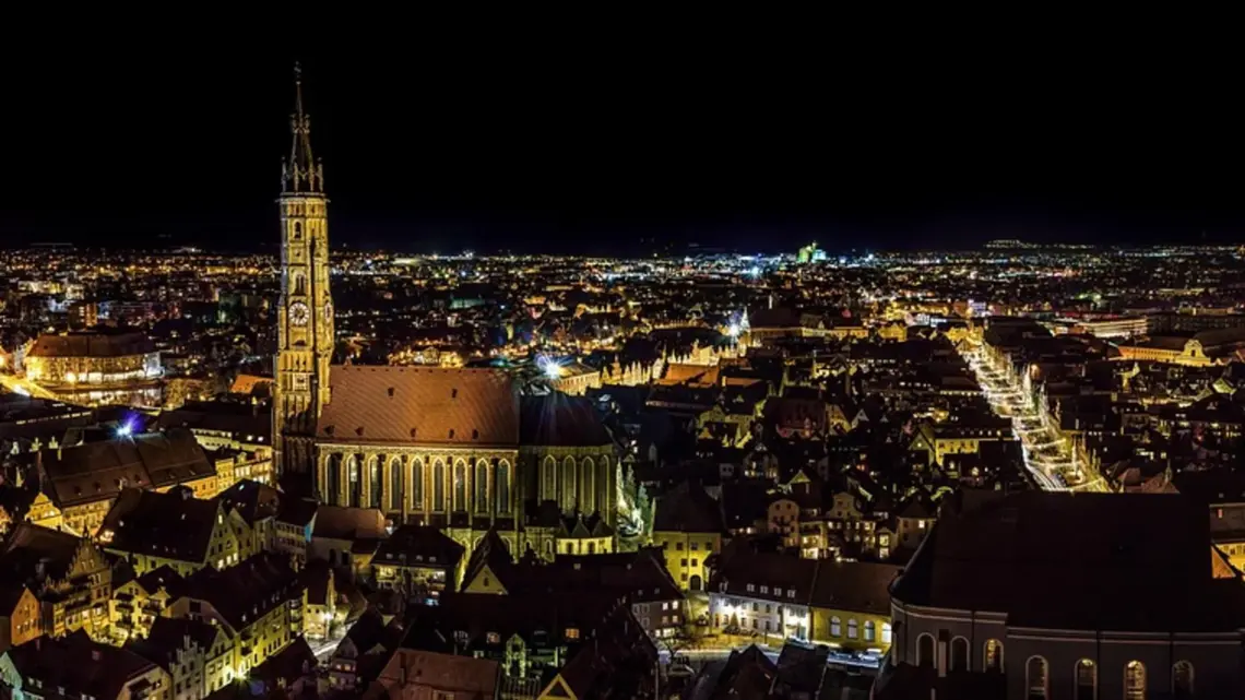 Über BDO-Online.de 1 Beleuchtete Altstadt mit hohem Kirchturm bei Nacht