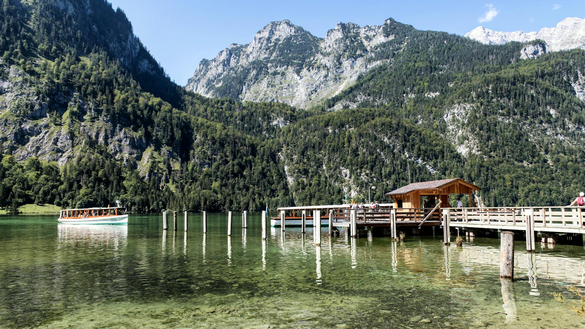 Picturesque Königssee with a wooden pier and tourboat in Bavaria, Germany.